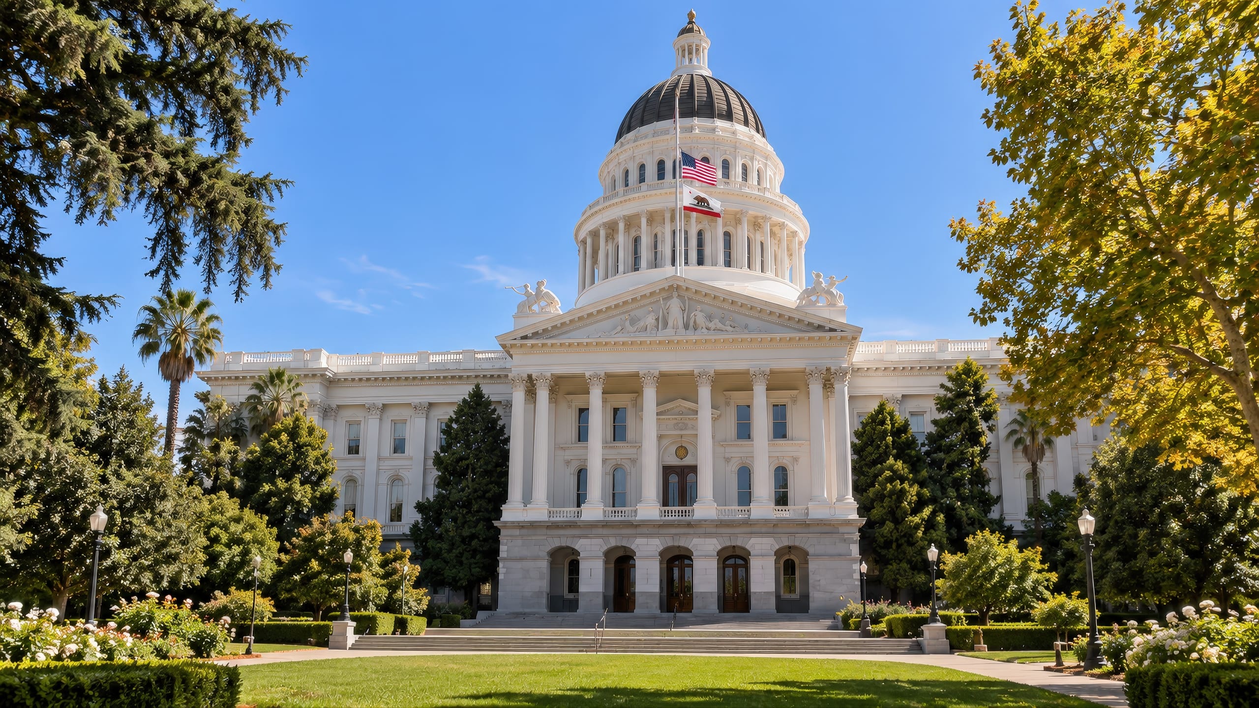 California State Capitol building in Sacramento on a clear, sunny late-September day, framed by trees and landscaped grounds.
